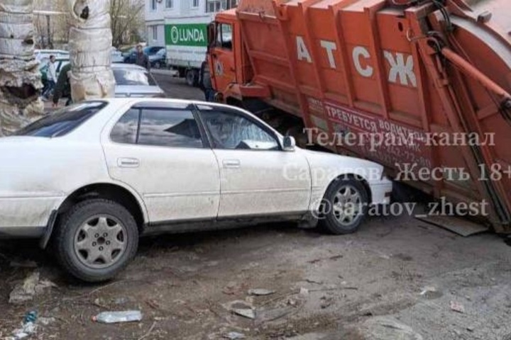 В саратовском дворе мусоровоз провалился в яму и чуть не упал на припаркованные машины